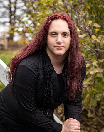 A red headed young trans women poses in her Senior Portraits