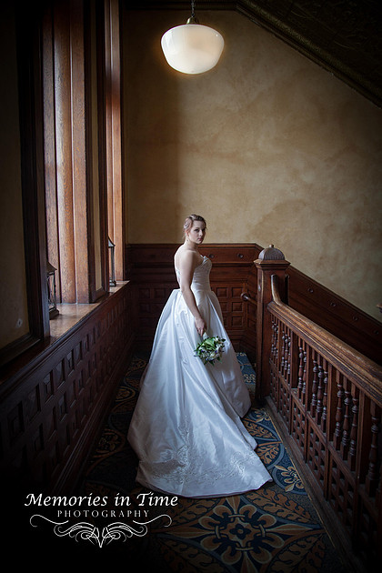 A Bride stands in her wedding gown at the top of the stairs before the start of her wedding