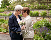 Older Brides with graying hair stand with their foreheads together after their wedding ceremony