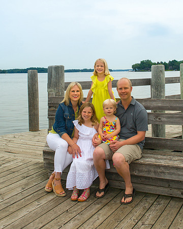A family with 3 daughters poses on the docks near Lake Minnetonka