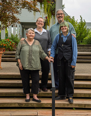 A family of three poses on a wall