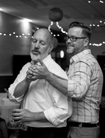 Two men dance at the wedding reception of their friends